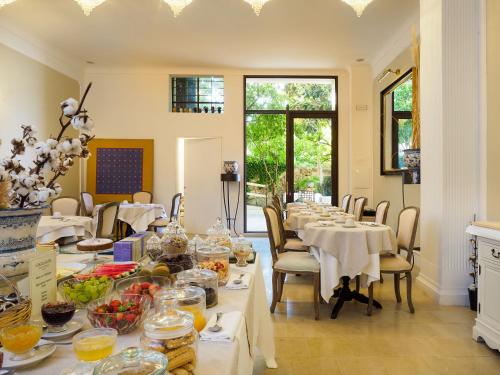 a dining room with tables and chairs with food on them at Gagliardi Boutique Hotel in Noto