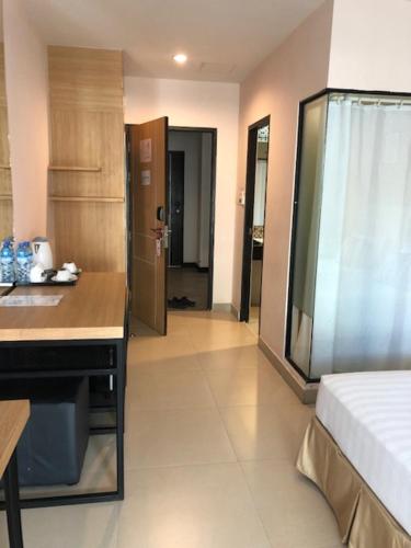 a room with a bed and a kitchen with a counter at Vogue Pattaya Hotel in Pattaya Central