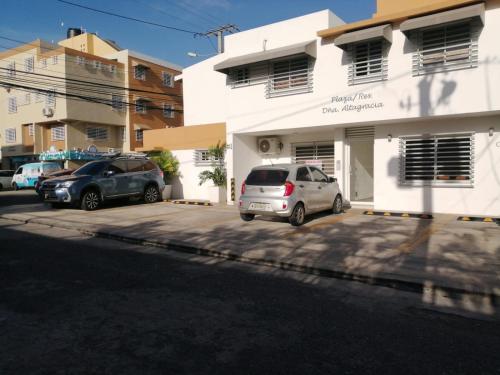 two cars parked in a parking lot in front of a building at Escape Studio Close to Agora Mall in Santo Domingo