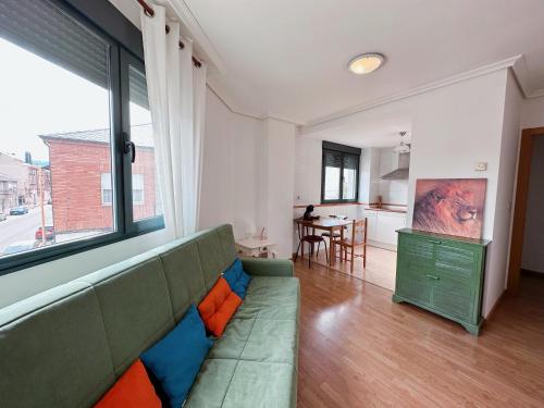 uma sala de estar com um sofá verde e uma cozinha em Suite Rigel em Ponferrada