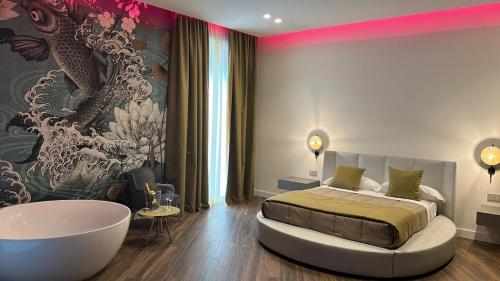 a bedroom with a large bed and a bath tub at PALAZZO CHINIAL in Torre del Greco