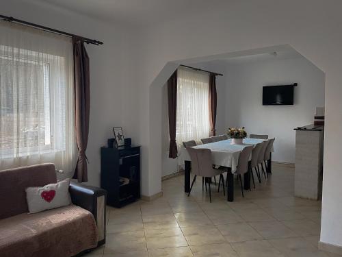 a dining room with a table and chairs and a couch at Casuta cu Dumbrava in Bran