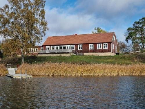 ein Haus auf der Seite eines Flusses mit einem Gebäude in der Unterkunft Barnens Ö in Väddö