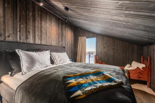 Kikut Alpin Lodge 2302 في جيلو: غرفة نوم بسرير وجدار خشبي