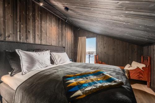 a bedroom with a bed and a wooden wall at SkiGeilo, Kikut Alpin Lodge in Geilo