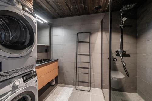 a bathroom with a shower and a washing machine at SkiGeilo, Kikut Alpin Lodge in Geilo