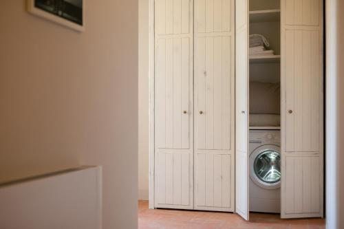 a white closet with a washing machine in it at La piccola Severina in Cortona