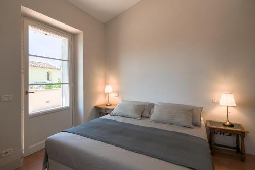 a bedroom with a bed and two lamps on two tables at La piccola Severina in Cortona