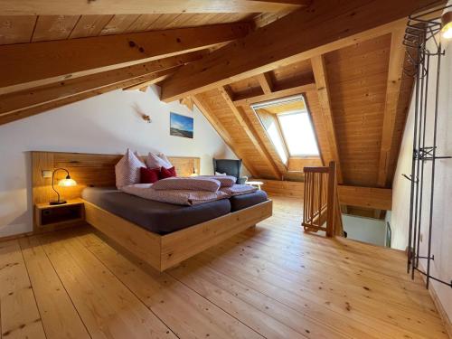 ein Schlafzimmer mit einem Bett in einem Zimmer mit Holzdecken in der Unterkunft See Cafe Toni in Rimsting