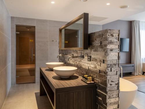a bathroom with two sinks and a mirror at Van Der Valk Hotel Zwolle in Zwolle