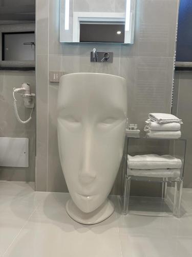a white toilet in a bathroom with towels at PALAZZO CHINIAL in Torre del Greco