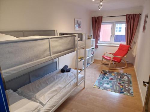 1 dormitorio con 2 literas y silla roja en W40 Mariazell en Mariazell