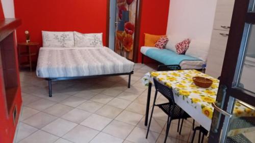 Habitación con cama, mesa, cama y sofá. en BeB Orio, en Capriate San Gervasio