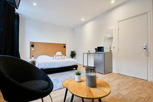 - un salon avec un lit, une chaise et une table dans l'établissement NG Prestige - Lille I Tourcoing I Haute - Balnéo - Netflix, à Tourcoing
