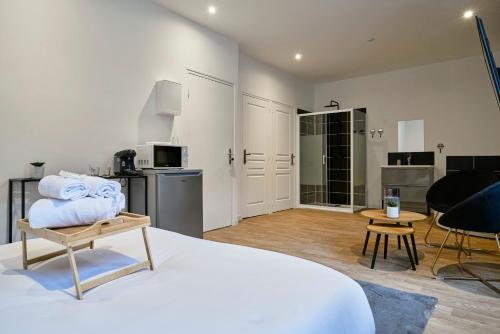 une chambre avec un lit et une table et une cuisine dans l'établissement NG Prestige - Lille I Tourcoing I Haute - Balnéo - Netflix, à Tourcoing