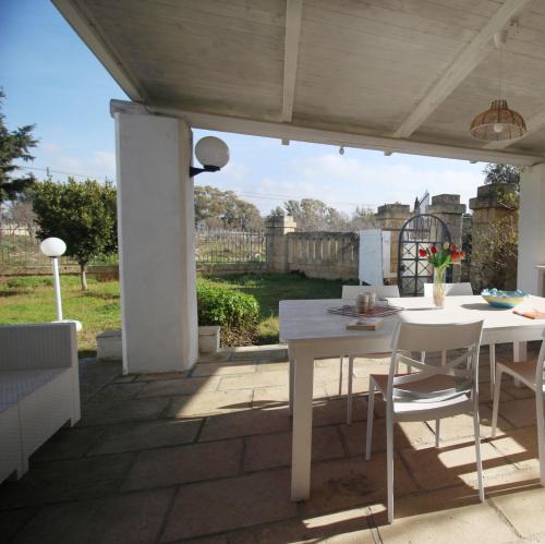 a white table and chairs on a patio at Villa Dei Lidi - HomeSalento com in Torre San Giovanni Ugento