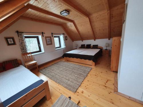 an attic room with two beds and a rug at Nadgalerii Soláň in Velké Karlovice