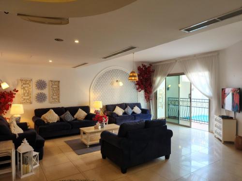 a living room with blue couches and a tv at Amwaj Resort For Families Only in Al Khobar