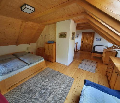 um quarto amplo com uma cama e tectos em madeira em Nadgalerii Soláň em Velké Karlovice