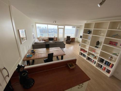 uma sala de estar com uma mesa e um sofá em Sterflat 173 em Egmond aan Zee
