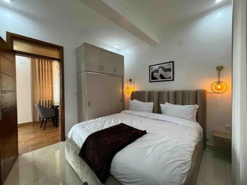 1 dormitorio con 1 cama blanca grande en una habitación en Nzuri Nest -Queen en Kigali