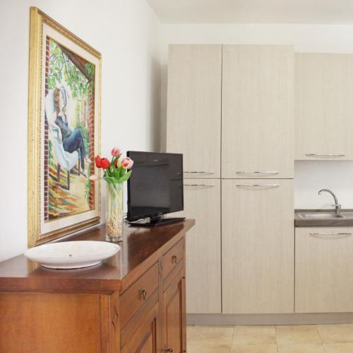 a kitchen with a counter with a sink and a tv at Villa Dei Lidi - HomeSalento com in Torre San Giovanni Ugento