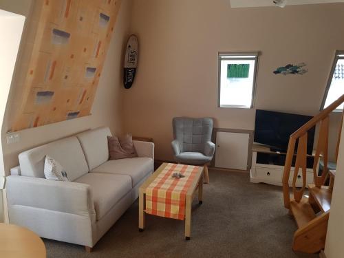 sala de estar con sofá y silla en Appartment Holiday, en Scharbeutz