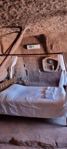 a bedroom with a bed in a rock wall at Wadi Rum stael Luxury Camp in Wadi Rum