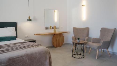 a bedroom with a bed and two chairs and a table at Diana Palace Hotel Zakynthos in Argasi