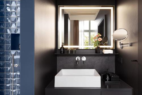 a bathroom with a white sink and a mirror at ESPLANADE Saarbrücken in Saarbrücken