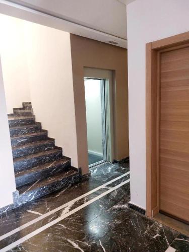 an empty room with a staircase in a building at Bel Appartement à AMWAJ Beach and Resorts in Casablanca