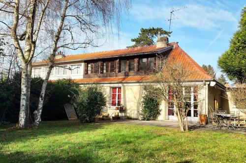 una vista exterior de una casa con patio en Maison dans parc privé (JO 2024), en La Celle-Saint-Cloud