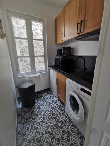 une cuisine avec une machine à laver et une fenêtre dans l'établissement Saint-Ger, what else !, à Saint-Germain-en-Laye