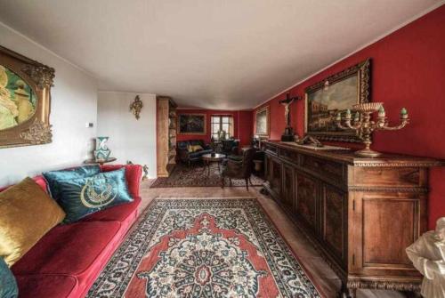 a living room with red walls and a red couch at Torre del 1300 Un atto damore in Castiglione