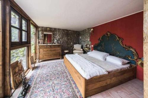 a bedroom with a large bed and a red wall at Torre del 1300 Un atto damore in Castiglione