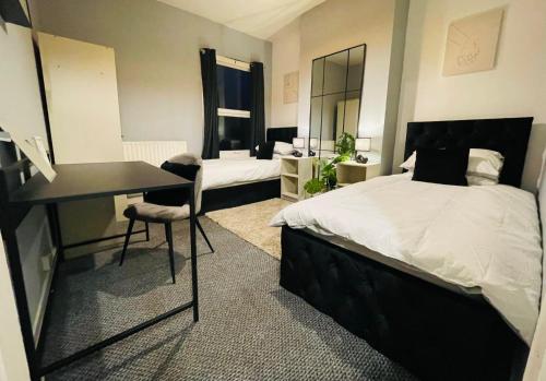 1 dormitorio con 1 cama y escritorio y 1 dormitorio con 1 cama en Cosy 3 Bed Home City Centre, en Parkside