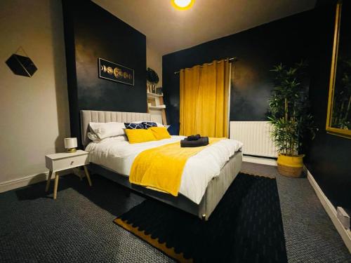 1 dormitorio con 1 cama grande con manta amarilla en Cosy 3 Bed Home City Centre, en Parkside