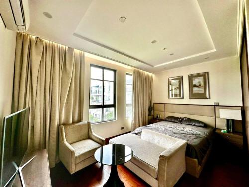 ein Schlafzimmer mit einem Bett, einem Stuhl und einem Fenster in der Unterkunft Princess Luxury Villa 6 Bedroom Hanoi in Hanoi