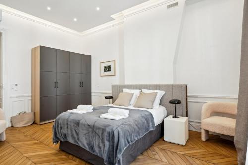 a bedroom with a large bed and a chair at 307-Suite Serbie - Superb apartment in Paris in Paris