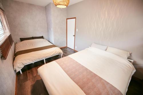 sypialnia z 2 łóżkami w pokoju w obiekcie Hakone Yumoto Base w mieście Hakone