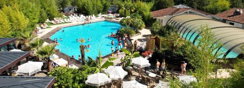 une vue aérienne d'une piscine dans un complexe hôtelier dans l'établissement Camping le Sen Yan, à Mézos