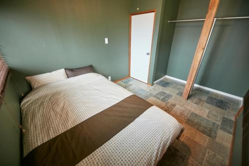 a bedroom with a bed in a room with a door at Hakone Yumoto Base in Hakone