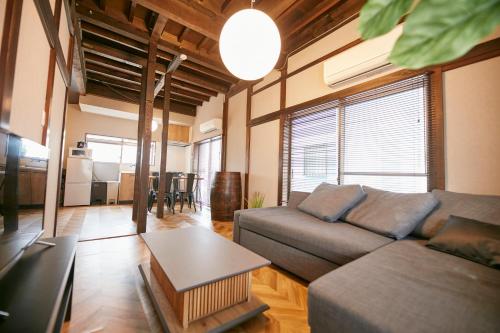 a living room with a couch and a table at Hakone Yumoto Base in Hakone
