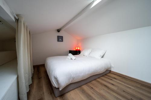 - une chambre avec un lit blanc et une lampe rouge dans l'établissement Atlantic Selection - Studio Ocean Side - À 200 mètres de l'Estacade, à Capbreton