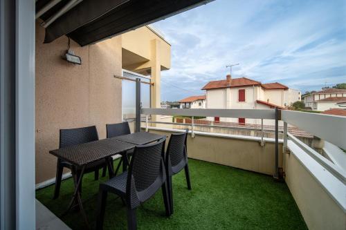un balcon avec une table et des chaises sur un immeuble dans l'établissement Atlantic Selection - Studio Ocean Side - À 200 mètres de l'Estacade, à Capbreton