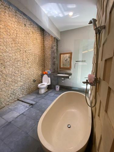 een badkamer met een bad en een toilet bij Villa Granatlia in Sanur