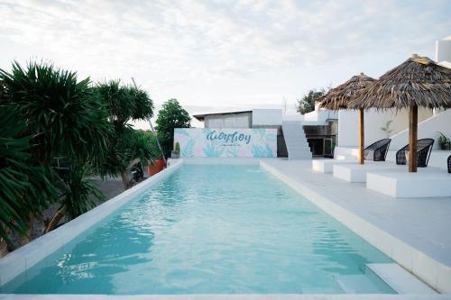 a swimming pool with blue water in a resort at Woywoy Paradise in Bira