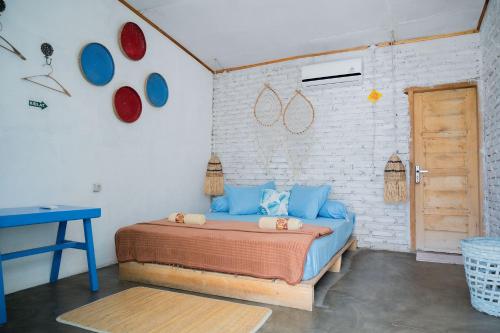 a bedroom with a bed with blue pillows on it at Woywoy Paradise in Bira