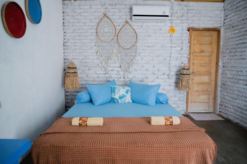 a bedroom with a large bed with blue pillows at Woywoy Paradise in Bira