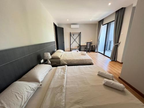 two beds in a large room with large windows at Galaria 4BR 17Pax NearTC, DinosaurLand, PS4, Netflix in Kuantan